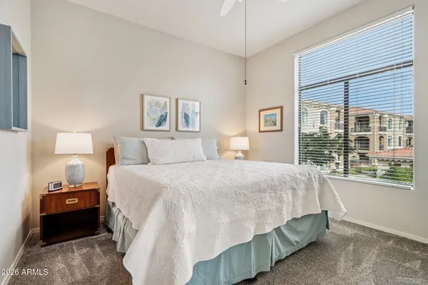 a bedroom with a bed and a large window