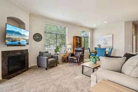 a living room with furniture a fireplace and a flat screen tv