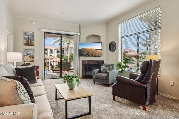 a living room with furniture a large window and a fireplace