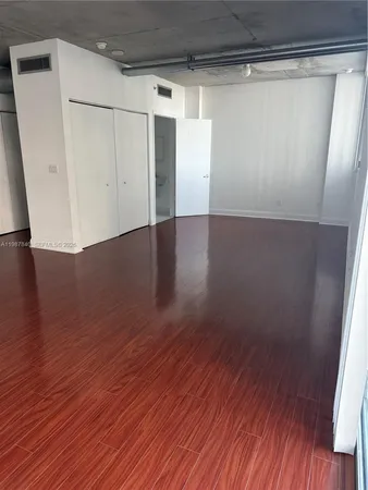 a view of a room with wooden floors and white walls