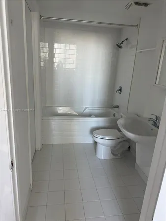 a bathroom with a granite countertop toilet and a shower