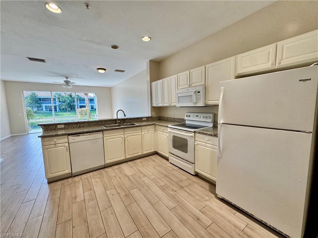 a kitchen with white cabinets and white appliances