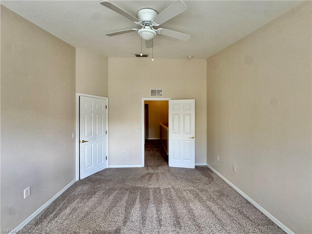 912 Hampton Circle, Unit 92 Naples, FL 34105 - Photo 11 of 31 Unfurnished bedroom featuring carpet, a high ceiling, and ceiling fan