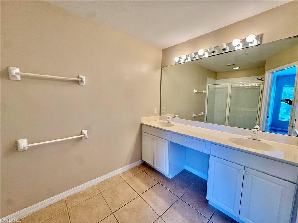 912 Hampton Circle, Unit 92 Naples, FL 34105 - Photo 12 of 31 Full bathroom with double vanity, a stall shower, and light tile patterned flooring
