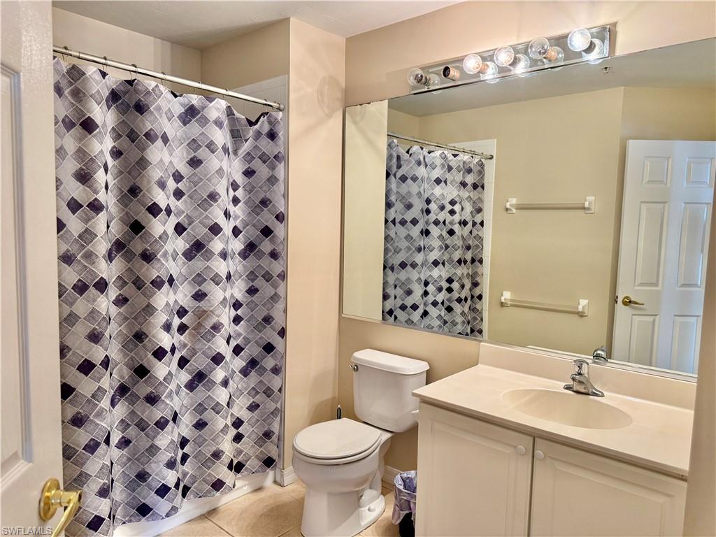 912 Hampton Circle, Unit 92 Naples, FL 34105 - Photo 16 of 31 Full bathroom featuring light tile patterned flooring, vanity, and a shower stall