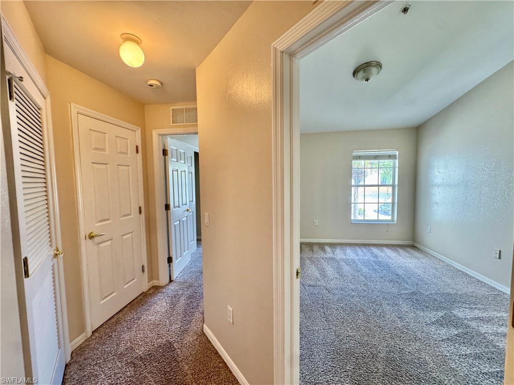 912 Hampton Circle, Unit 92 Naples, FL 34105 - Photo 17 of 31 Hall with dark carpet and baseboards