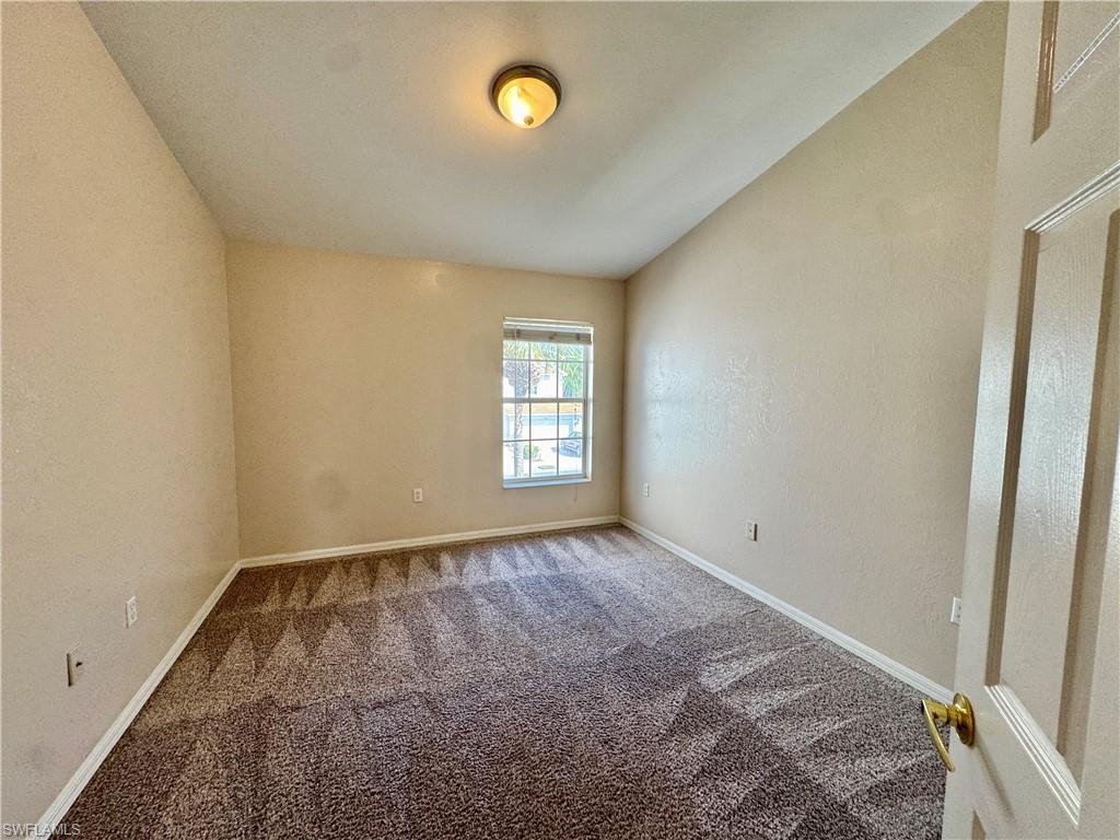912 Hampton Circle, Unit 92 Naples, FL 34105 - Photo 18 of 31 Spare room with carpet floors and a textured wall