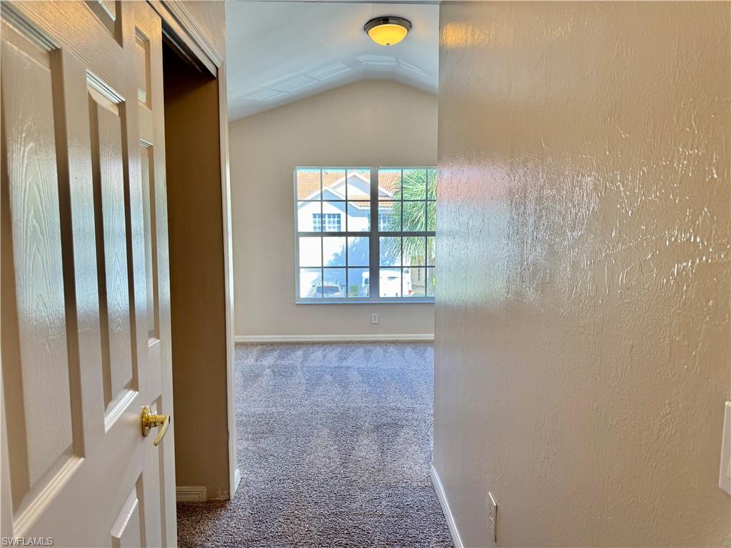 912 Hampton Circle, Unit 92 Naples, FL 34105 - Photo 20 of 31 Hall with carpet flooring, vaulted ceiling, and a textured wall