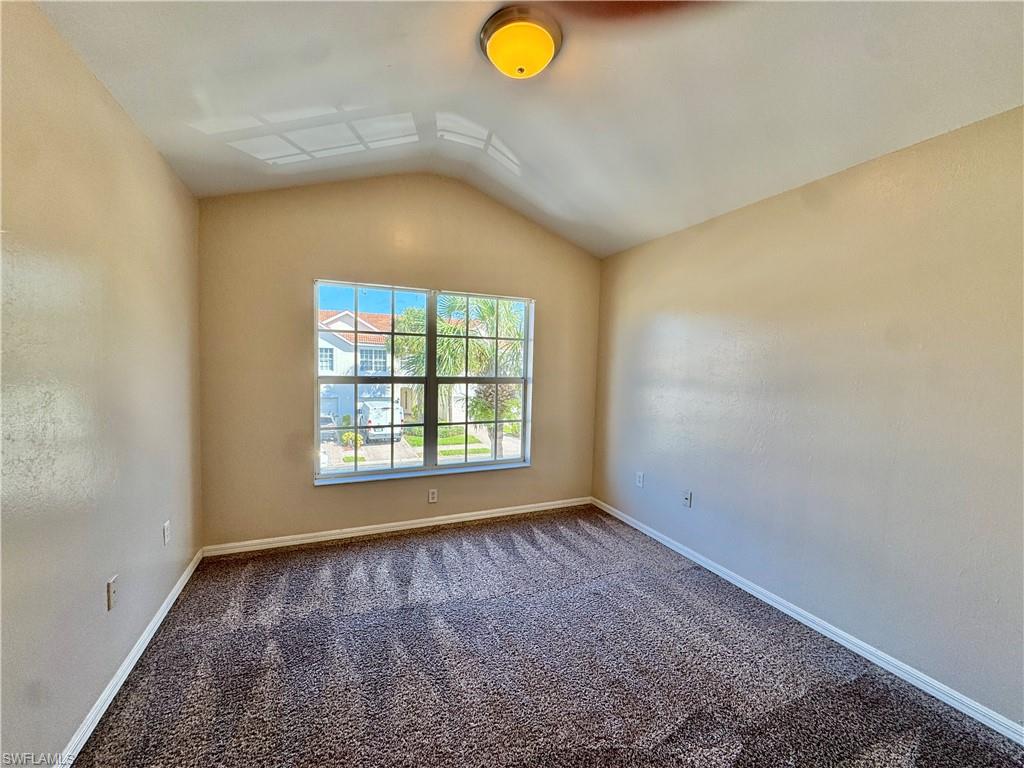 912 Hampton Circle, Unit 92 Naples, FL 34105 - Photo 21 of 31 Carpeted spare room featuring vaulted ceiling and baseboards