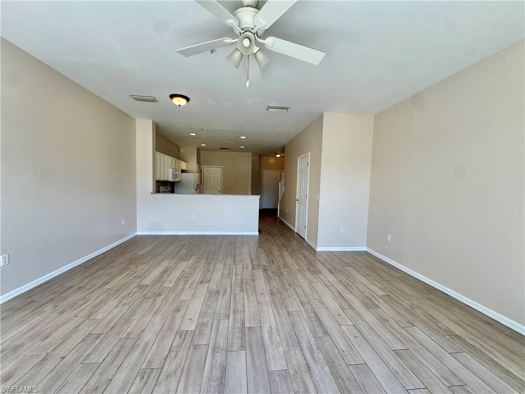 912 Hampton Circle, Unit 92 Naples, FL 34105 - Photo 5 of 31 Unfurnished living room with light wood-type flooring and ceiling fan