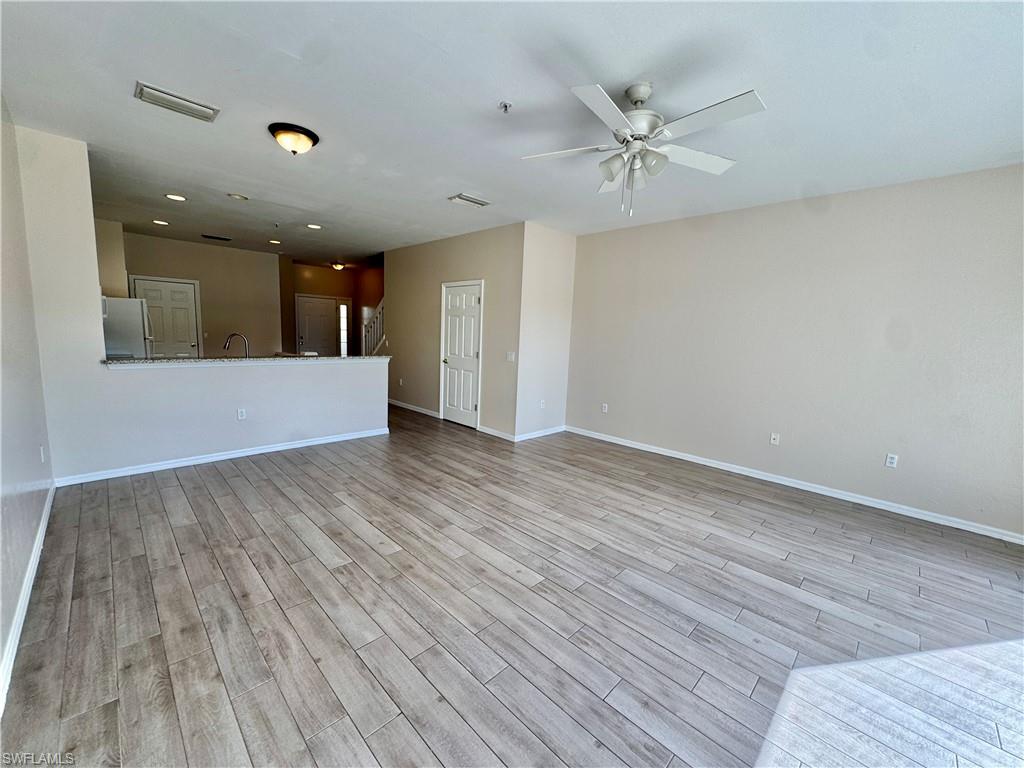 912 Hampton Circle, Unit 92 Naples, FL 34105 - Photo 6 of 31 Unfurnished living room with light wood-style floors and ceiling fan