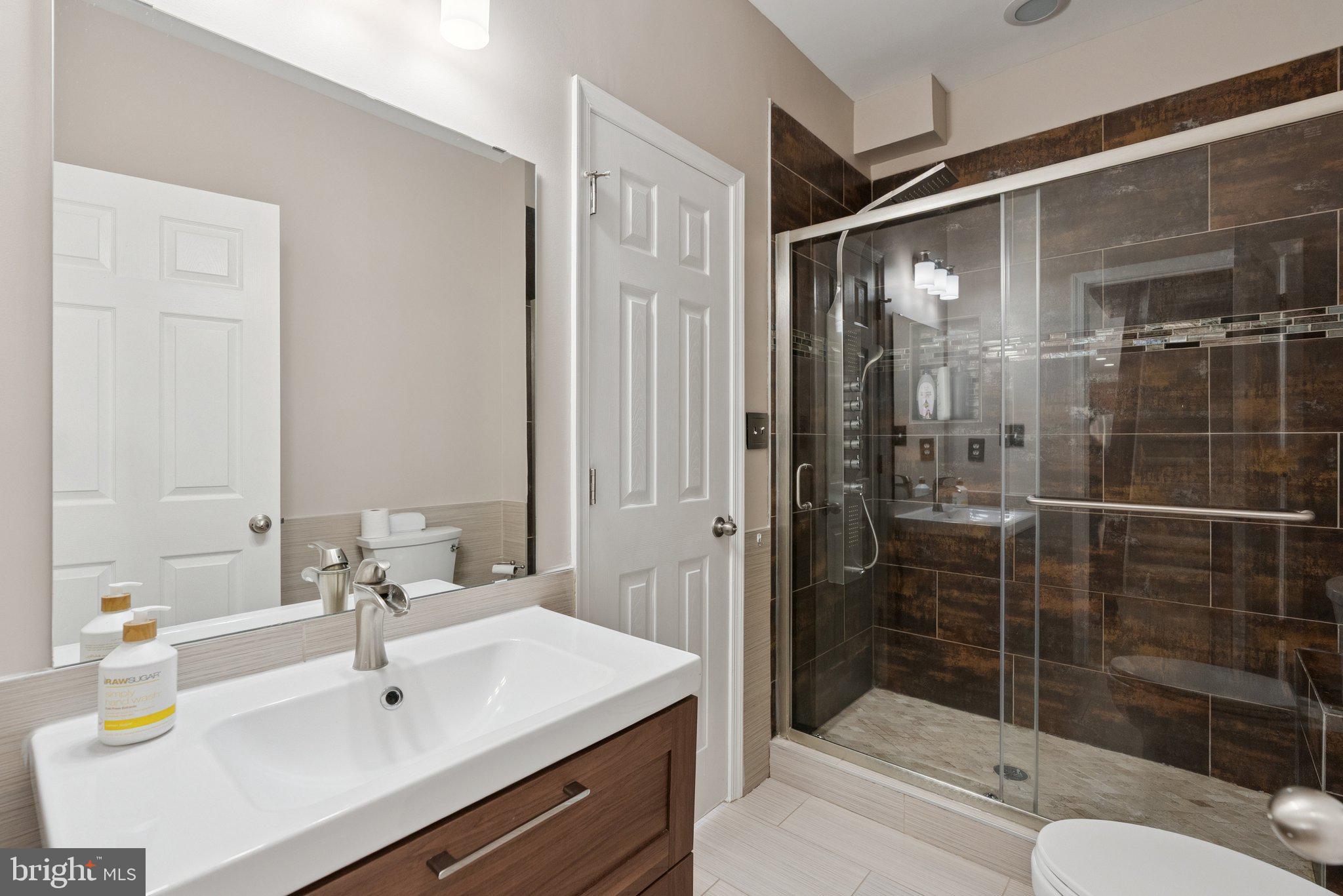 5402 Loggerhead Place Woodbridge, VA 22193 - Photo 27 of 40 a bathroom with a shower sink and mirror