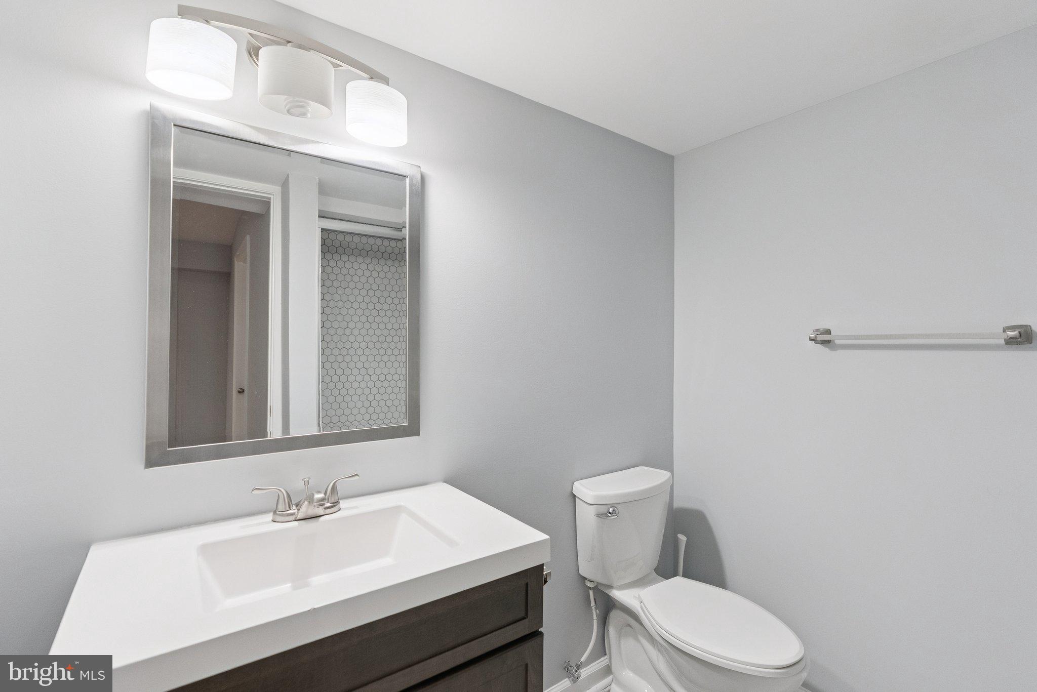 5402 Loggerhead Place Woodbridge, VA 22193 - Photo 32 of 40 a bathroom with a sink a toilet and mirror
