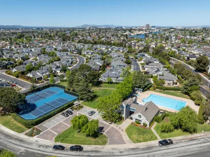 an aerial view of residential houses with outdoor space and parking