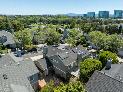 an aerial view of multiple houses with a yard