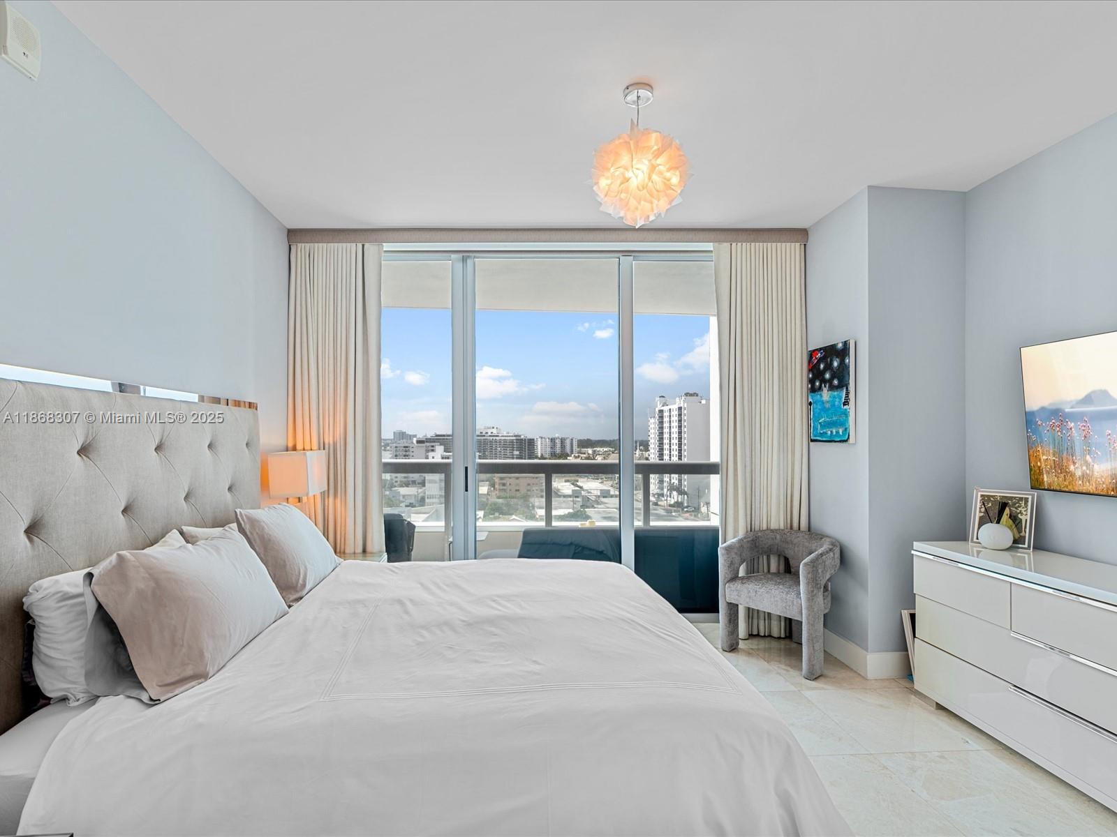 6899 Collins Avenue, Unit 1010 Miami Beach, FL 33141 - Photo 14 of 37 a bedroom with a bed and a large window
