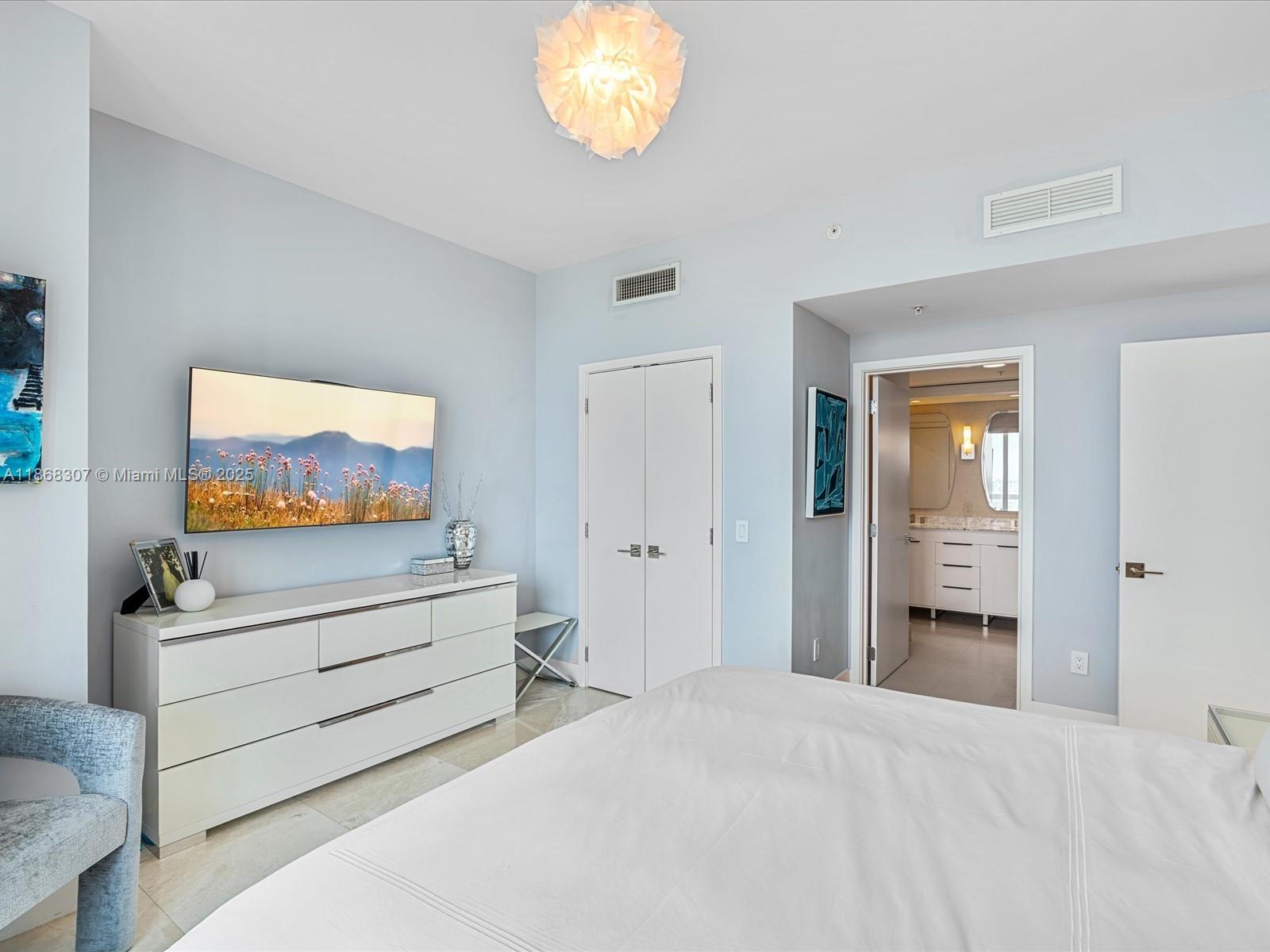 6899 Collins Avenue, Unit 1010 Miami Beach, FL 33141 - Photo 16 of 37 a bedroom with furniture and a flat screen tv