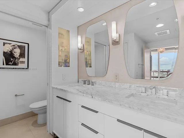 a bathroom with a granite countertop sink mirror and toilet