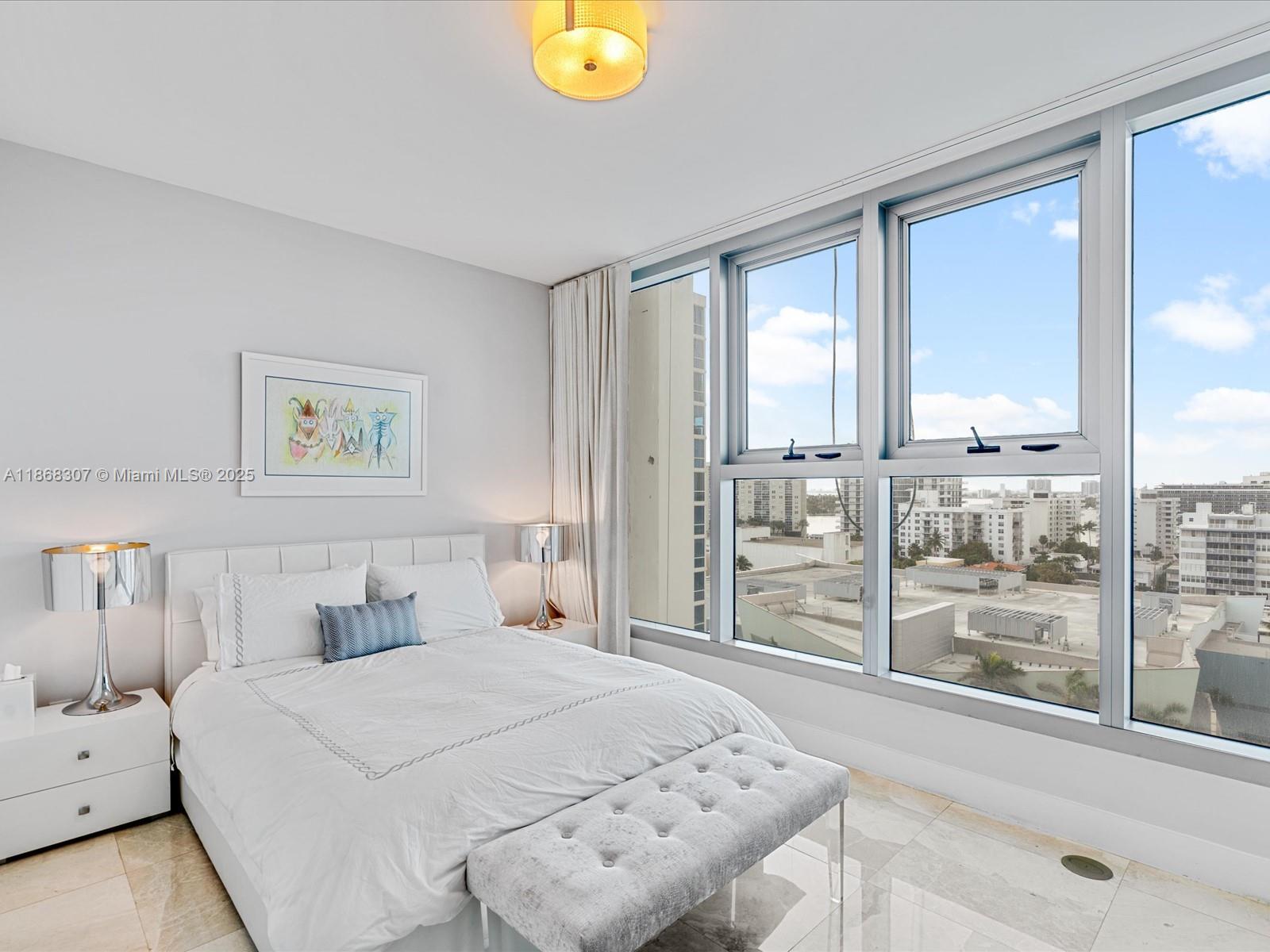 6899 Collins Avenue, Unit 1010 Miami Beach, FL 33141 - Photo 19 of 37 a bedroom with a bed and a large window with outer view