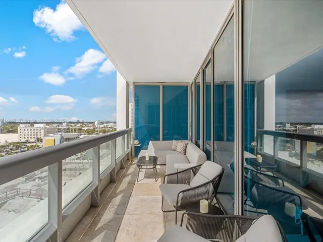 a balcony with furniture and a floor to ceiling window