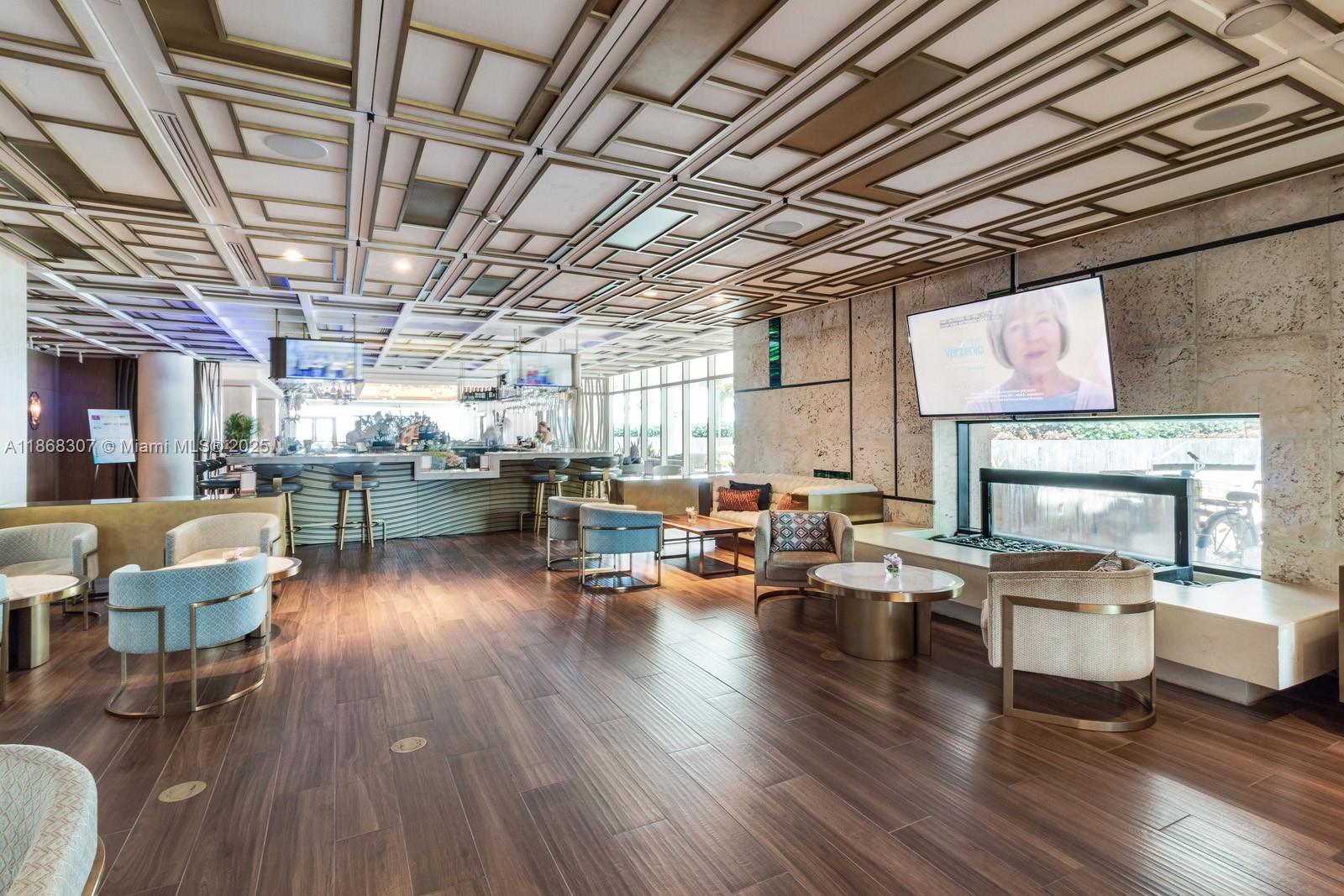 6899 Collins Avenue, Unit 1010 Miami Beach, FL 33141 - Photo 31 of 37 a living room with lots of furniture wooden floor and flat screen tv