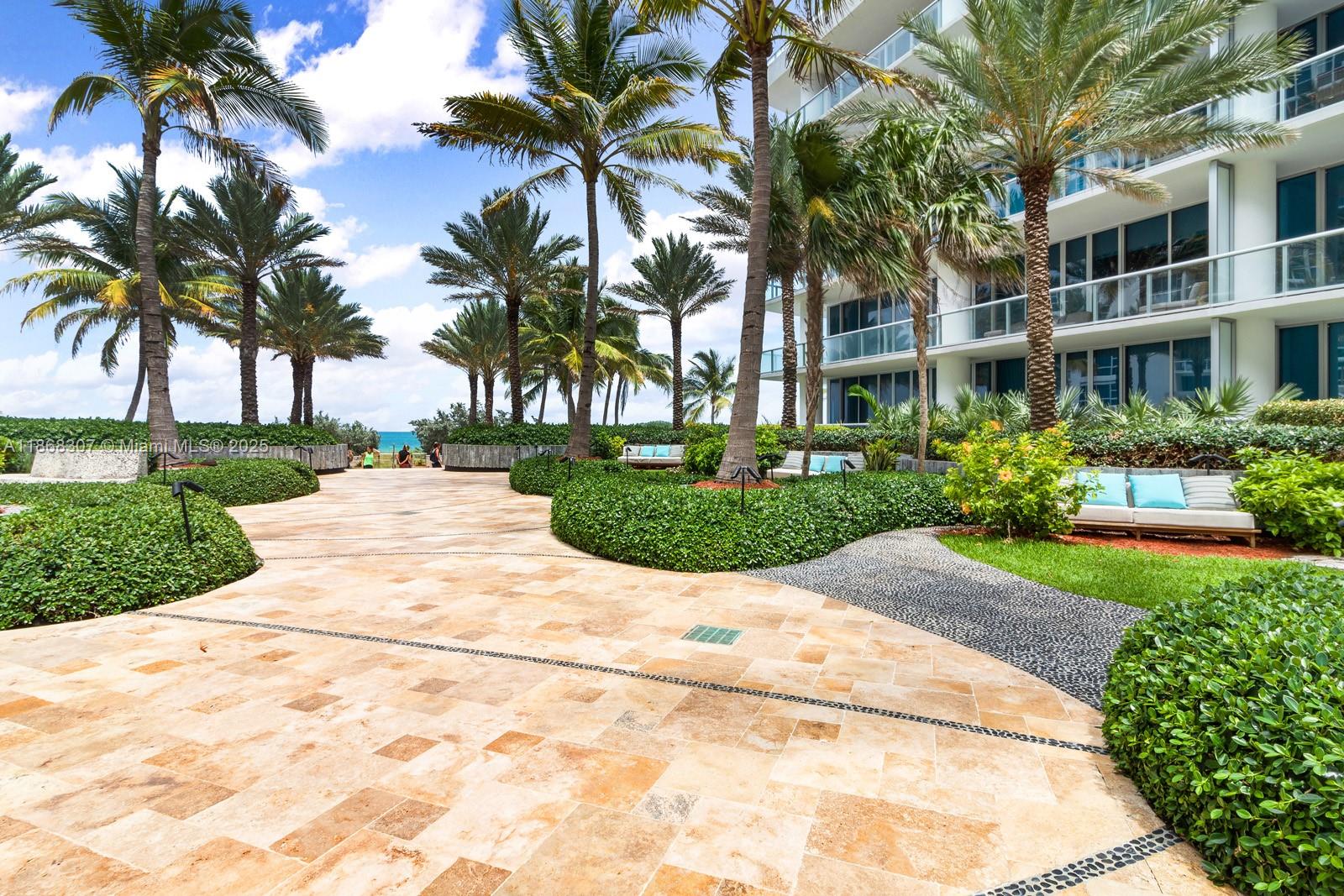 6899 Collins Avenue, Unit 1010 Miami Beach, FL 33141 - Photo 35 of 37 a view of yellow house with a yard and potted plants