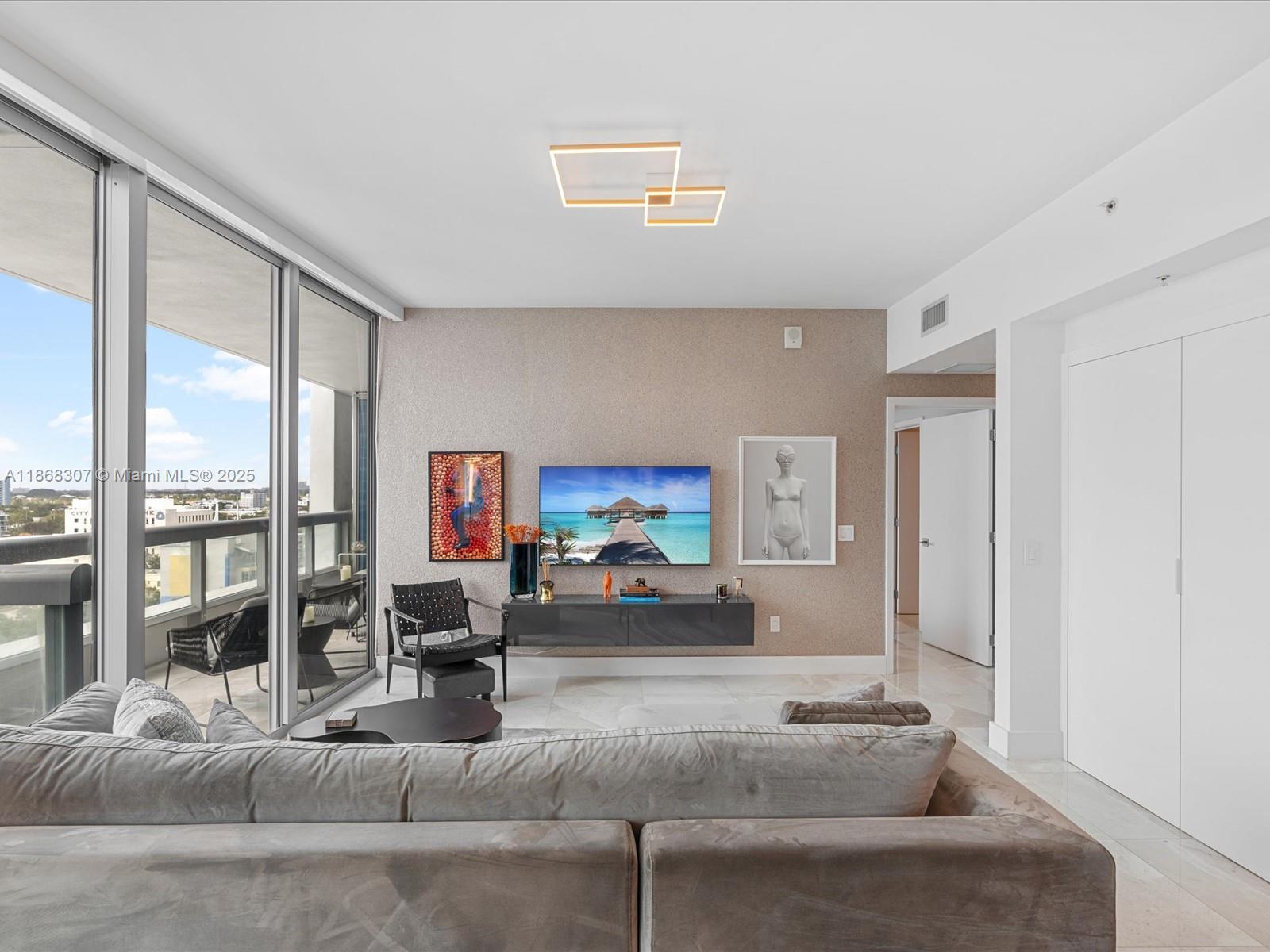 6899 Collins Avenue, Unit 1010 Miami Beach, FL 33141 - Photo 4 of 37 a living room with furniture and a large window