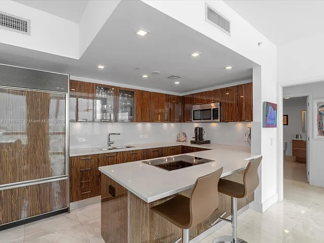 a kitchen with a table chairs refrigerator and cabinets