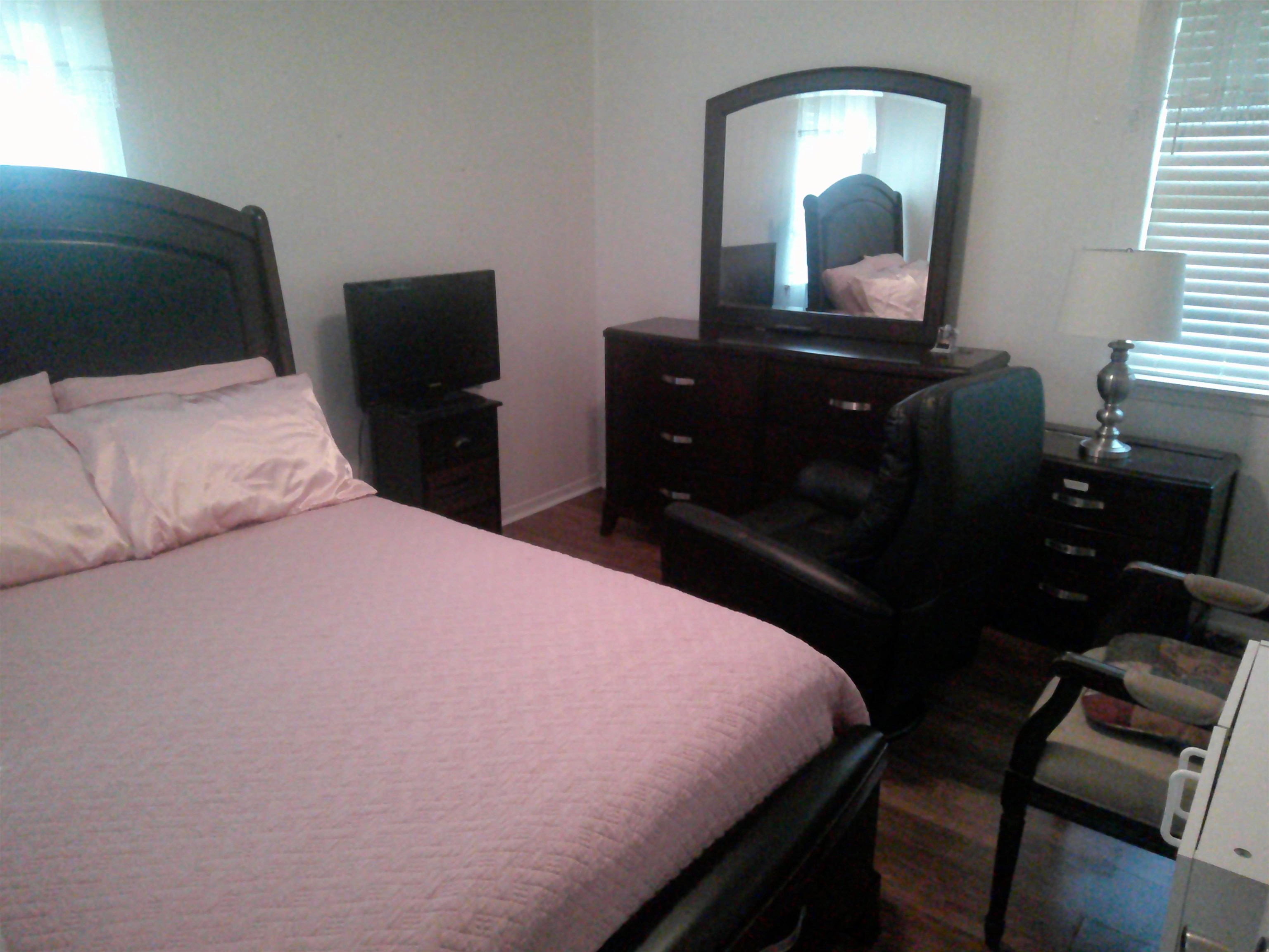 4374 Ford Road Memphis, TN 38109 - Photo 7 of 14 a bedroom with a bed and a mirror on dresser
