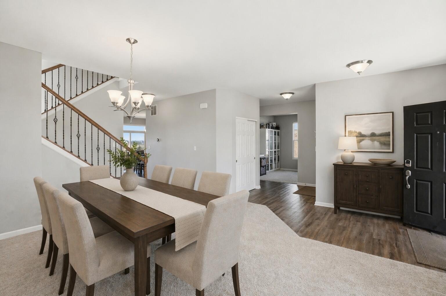 10322 Adler Cove St. John, IN 46373 - Photo 8 of 26 a view of a dining room and livingroom with furniture wooden floor a chandelier