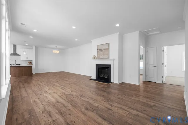 a view of empty room with wooden floor and fireplace
