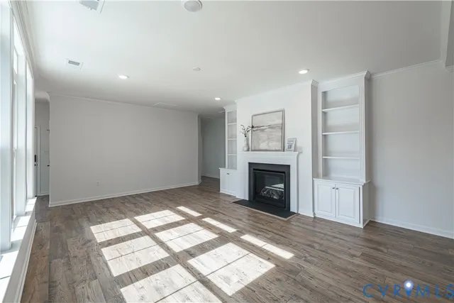 a view of empty room with wooden floor and fireplace