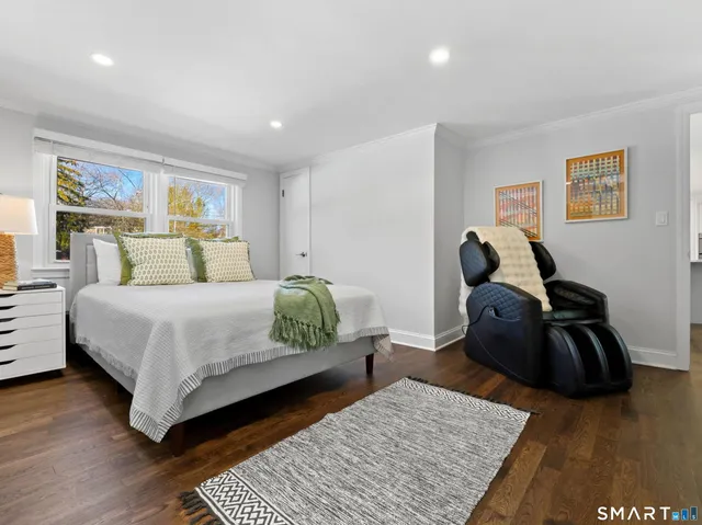 a bedroom with a bed and wooden floor