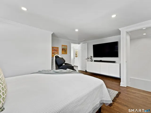 a bedroom with a bed and a flat screen tv