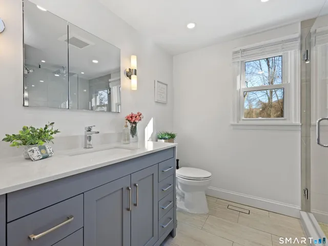 a bathroom with a sink a toilet and a window