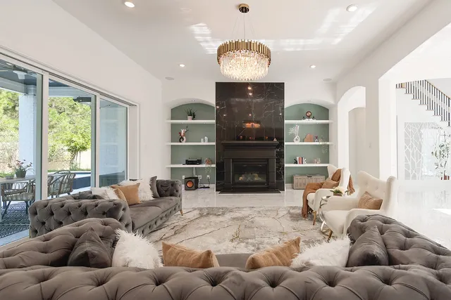 a living room with furniture fireplace and a large window