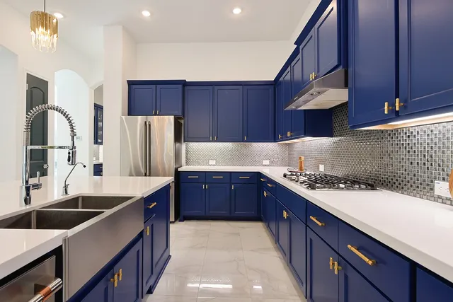 a kitchen with stainless steel appliances granite countertop a sink a stove and a refrigerator