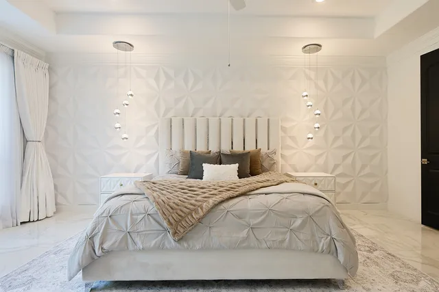 a bedroom with a bed and a white wall