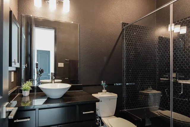 a bathroom with a sink mirror toilet and shower