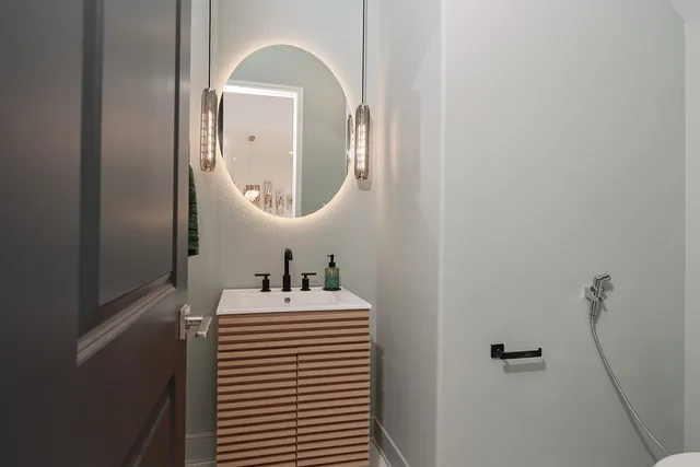 a bathroom with a sink a toilet and mirror