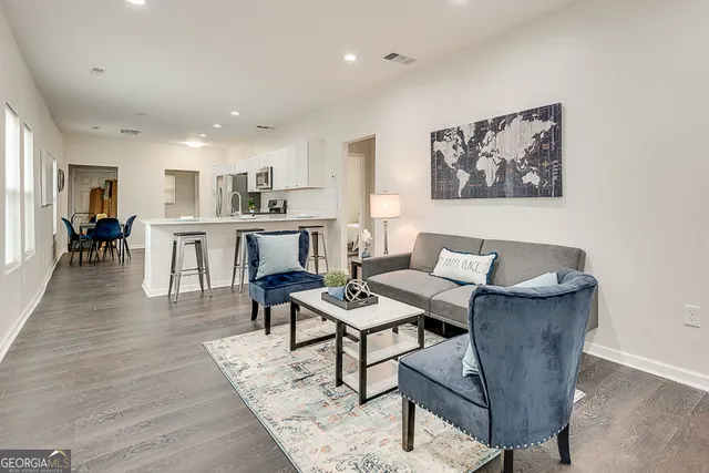 a living room with furniture and kitchen view