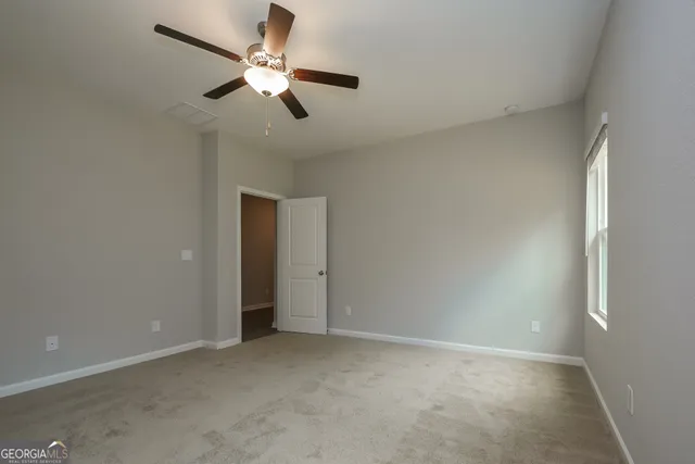 an empty room with closet and a chandelier fan