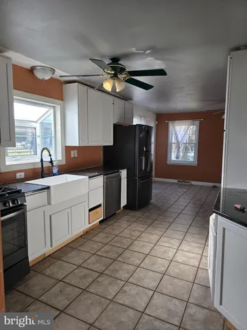 a kitchen with stainless steel appliances a sink cabinets and a window