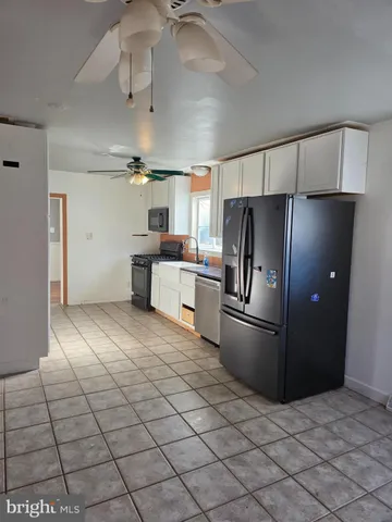 a kitchen with stainless steel appliances granite countertop a refrigerator a stove and a sink