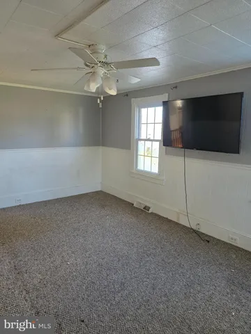 en empty room with windows and fan