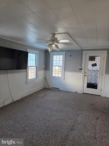 an empty room with windows and fireplace