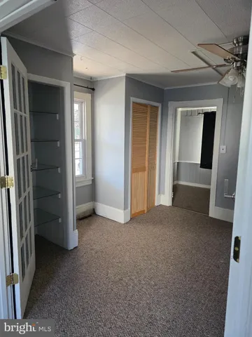 an empty room with closet and mirrors
