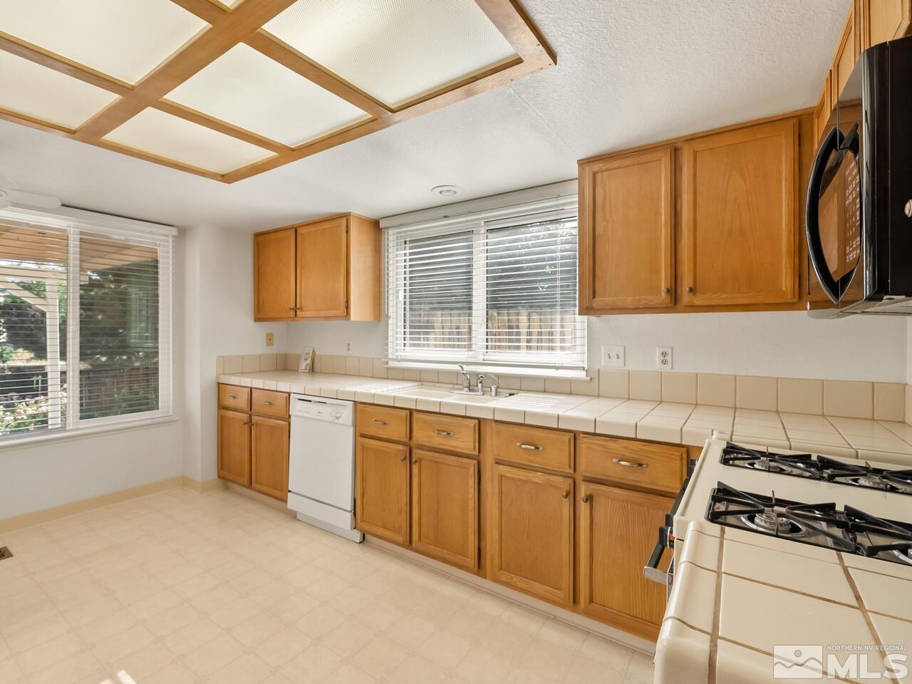 5670 West Rainbow Ridge Court Reno, NV 89523 - Photo 11 of 36 a kitchen with a stove a sink and a microwave