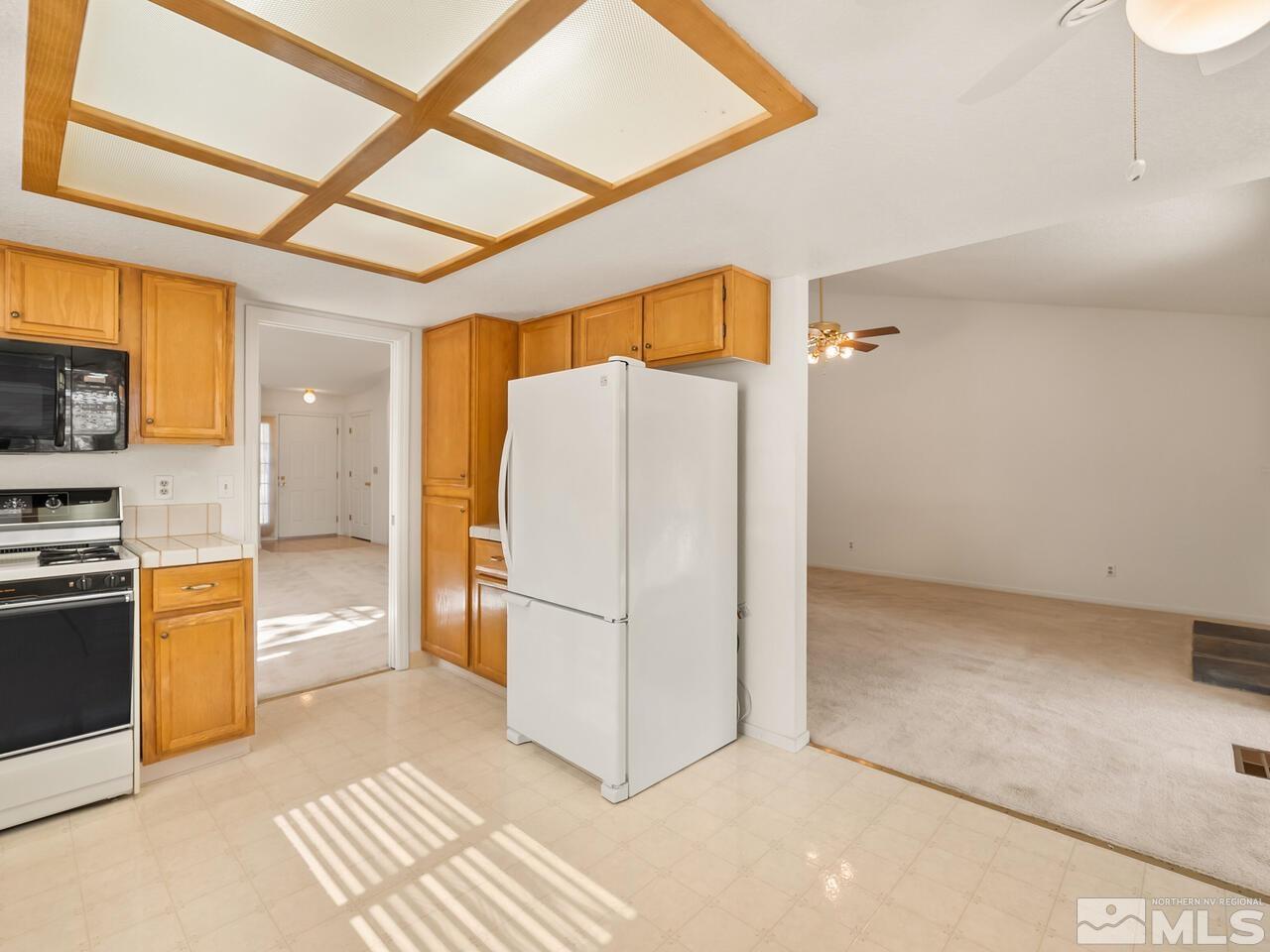 5670 West Rainbow Ridge Court Reno, NV 89523 - Photo 12 of 36 a kitchen with stainless steel appliances a refrigerator and a stove