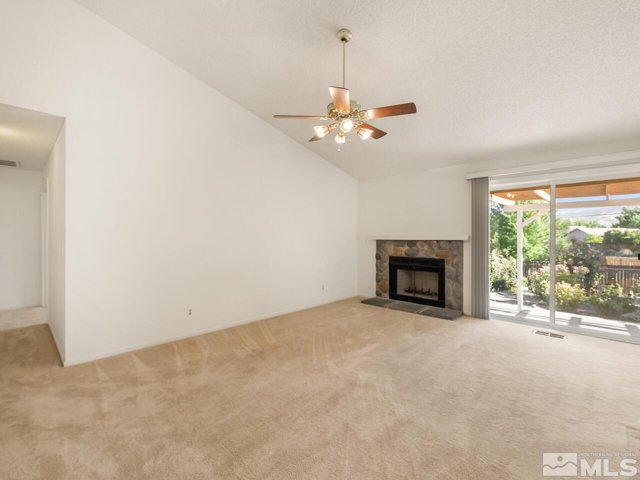 5670 West Rainbow Ridge Court Reno, NV 89523 - Photo 15 of 36 an empty room with fireplace and a ceiling fan